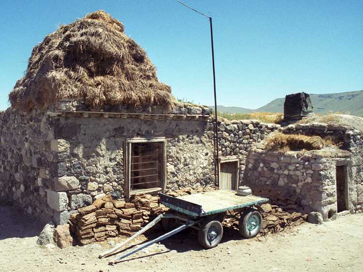 Hay is stacked on the roof so that during the harsh winter it can be pulled down through a hole in the ceiling and fed to animals in the room below.