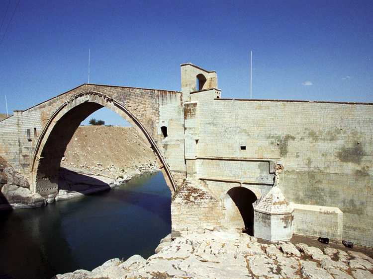 Malabadi Bridge, a stone bridge built in the 12th century. A bridge built in the 1950s carries traffic. The Batman River flows beneath. 